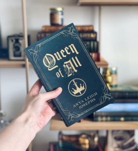 Dark teal book cover that reads "Queen of All" by Anya Leigh Josephs